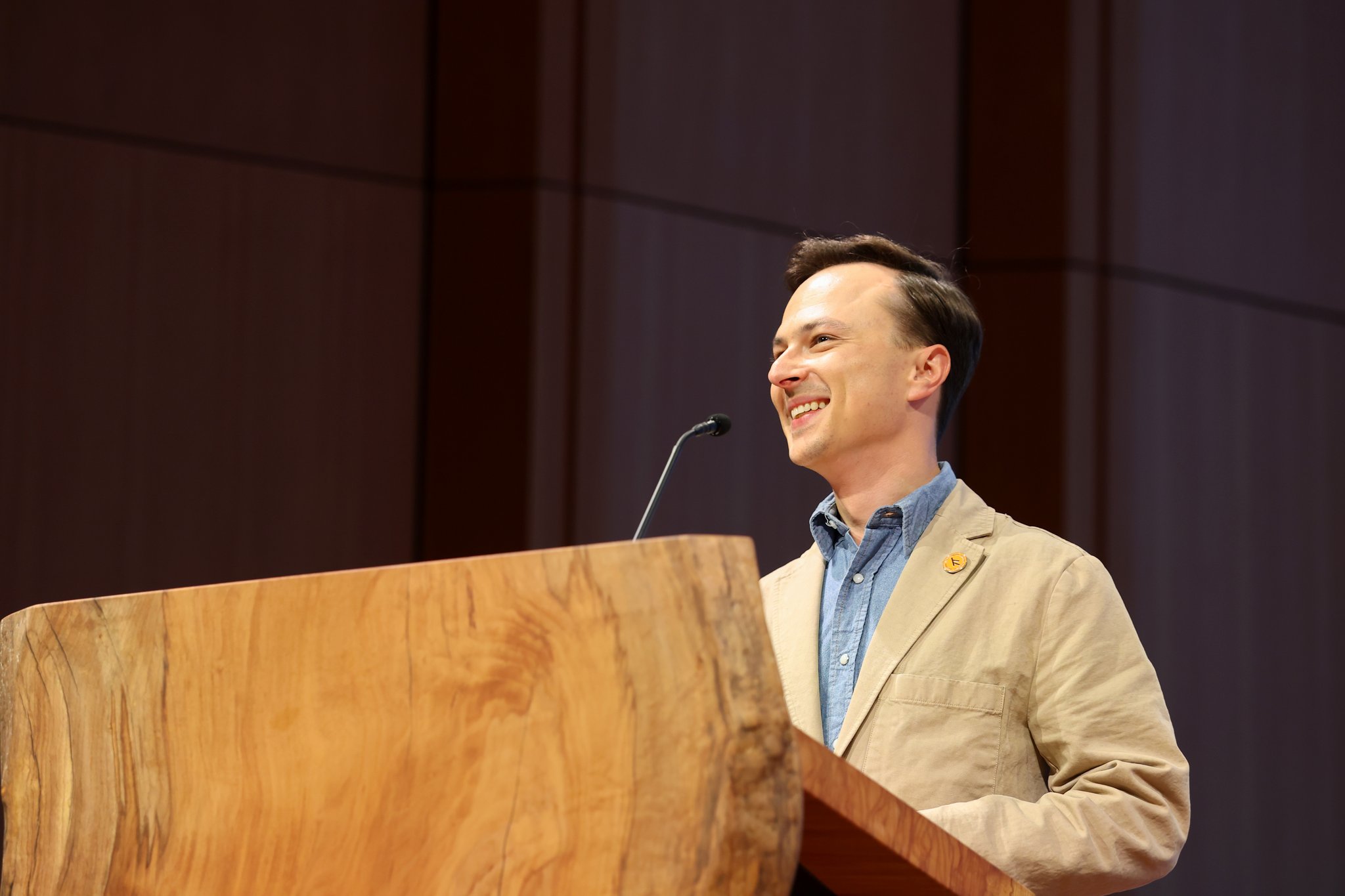 Courtland Miller smiling while hosting a public program
